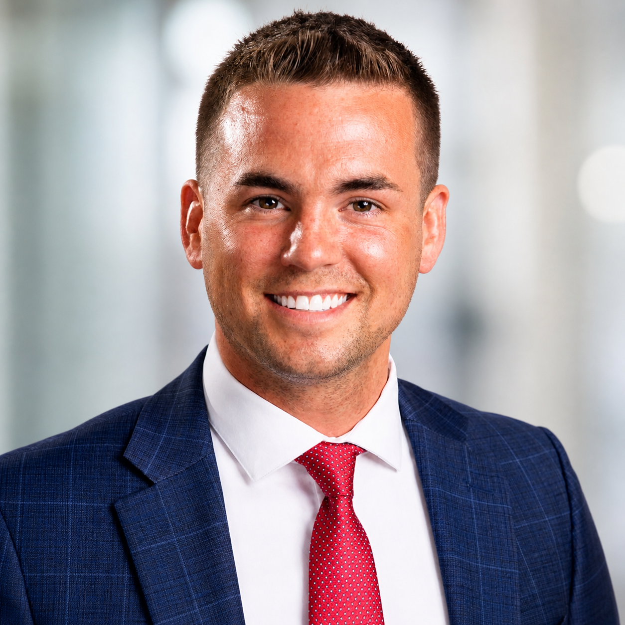A man in a suit and tie smiling for the camera.